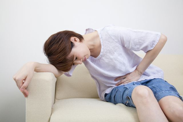 腹痛で苦しむ女性